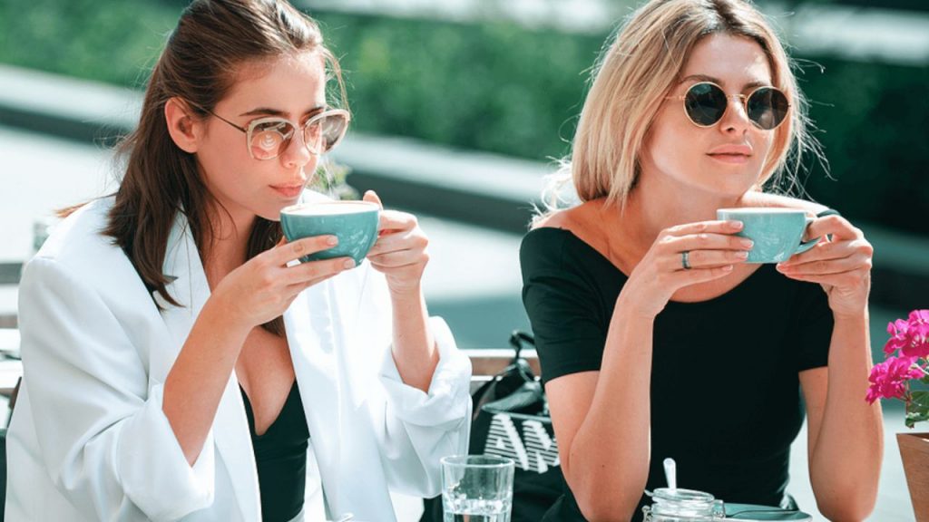 Two women having a cup of coffee outside at a nice cafe discussing the closer connection test
