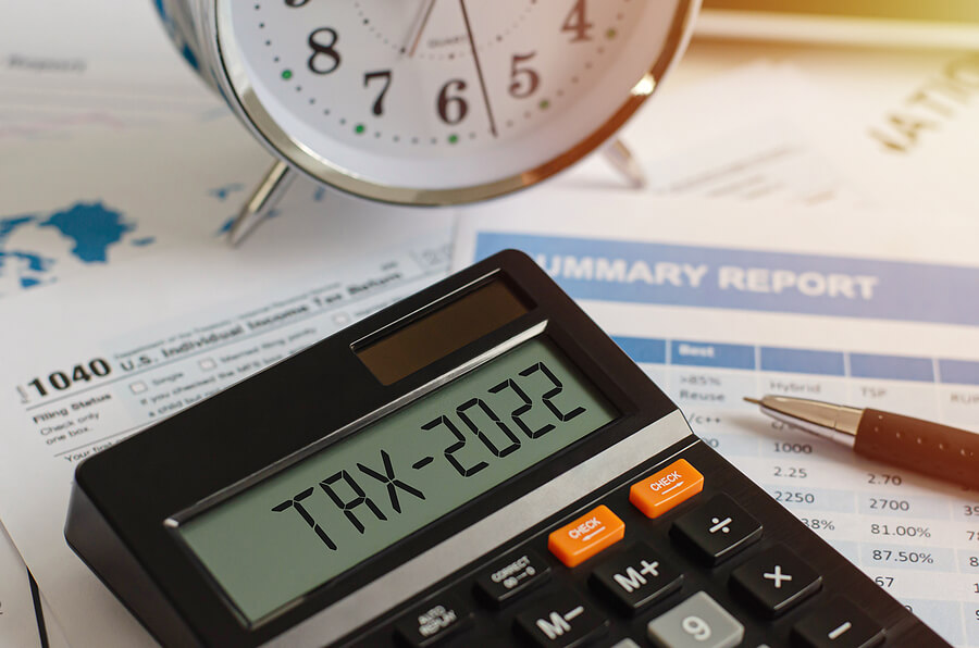 A calculator displays TAX-2022. Filing taxes for expats in 2022