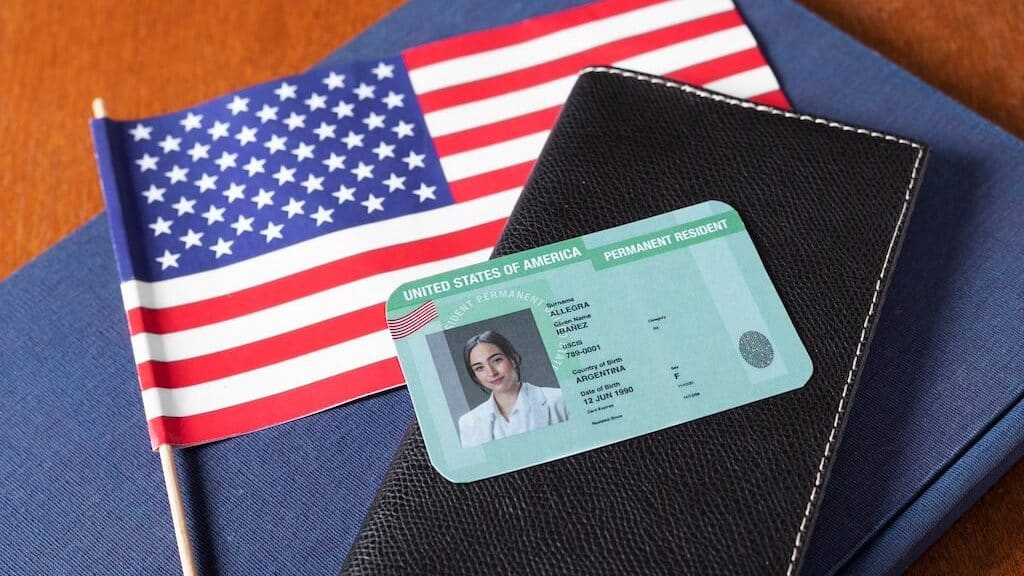 Abandoning your Green card. A photo of the American flag with a Green card over top of it.