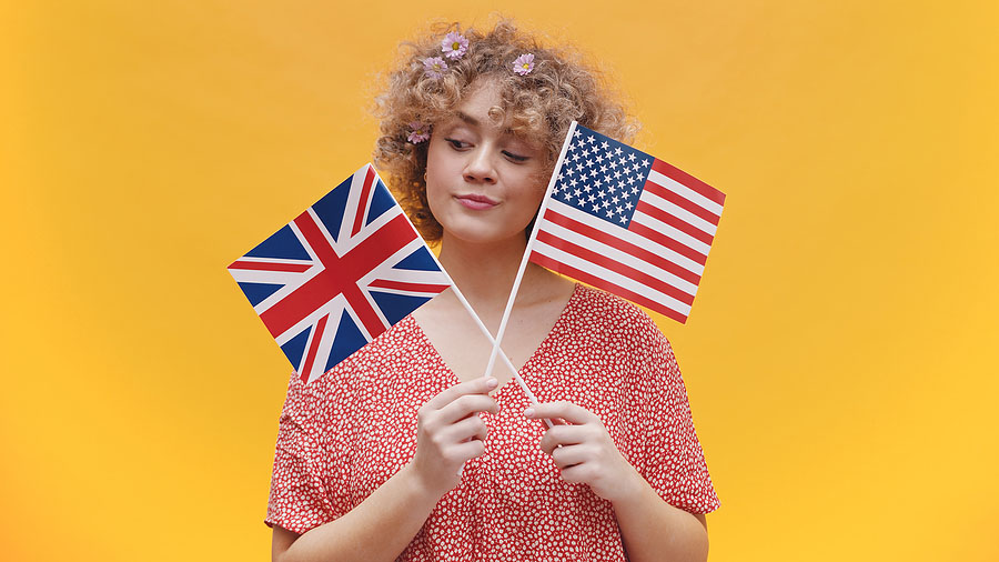 A woman holds two flags signifying the US UK Tax Treaty. 