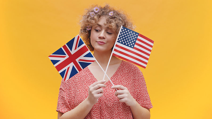 A woman holds two flags signifying the US UK Tax Treaty.