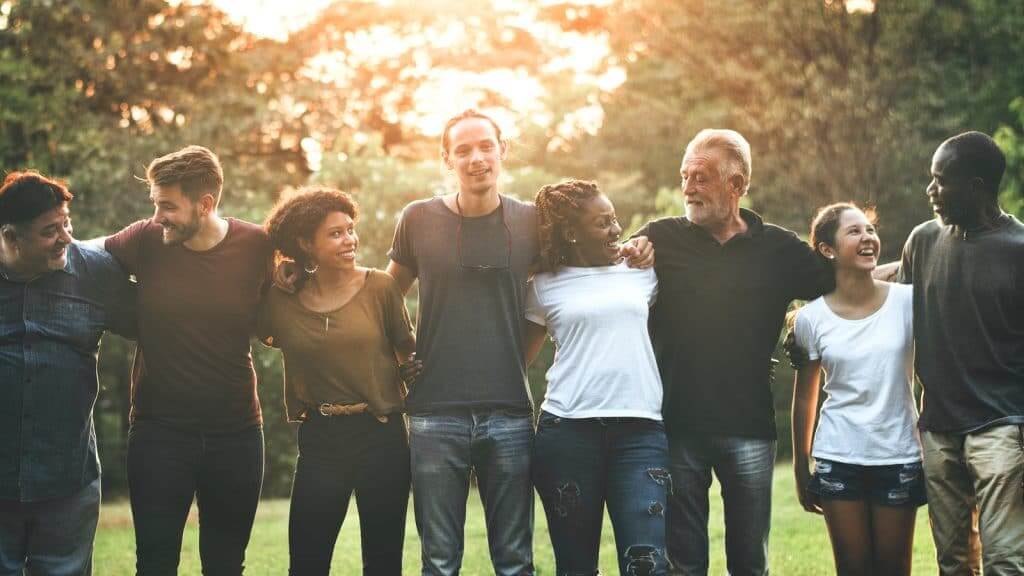 Cheerful diverse people huddling in the park not thinking about their extension for the tax season