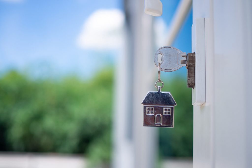 Image of key with home keychain in the door. Like an expat just bought a home abroad.
