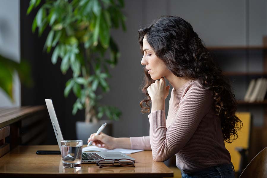 Woman sits at her laptop wondering if expats can e-file their US taxes.