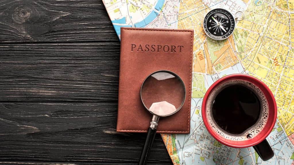 Picture of a passport with a cup of coffee, map and compass. 