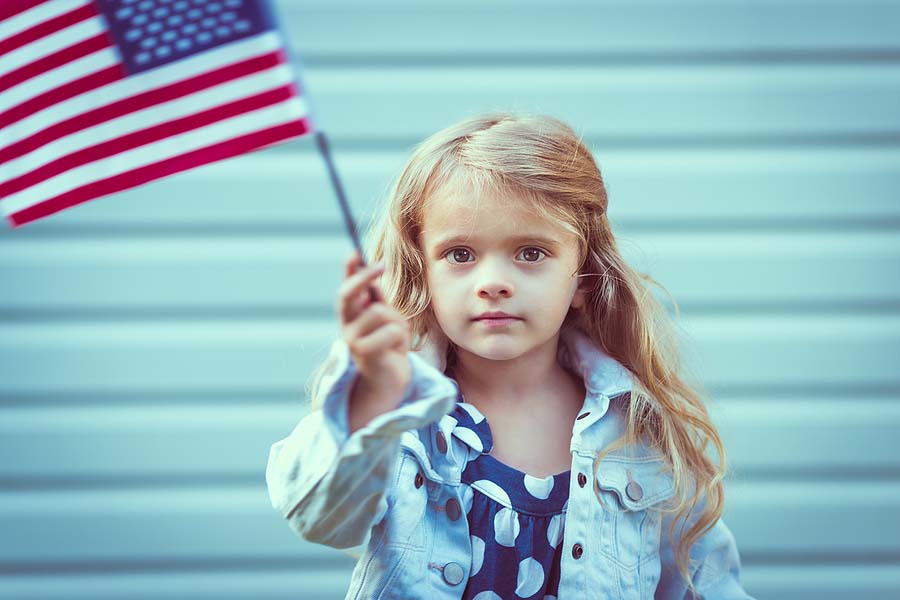 Child born abroad waving a US flag because her parents are US citizens. 